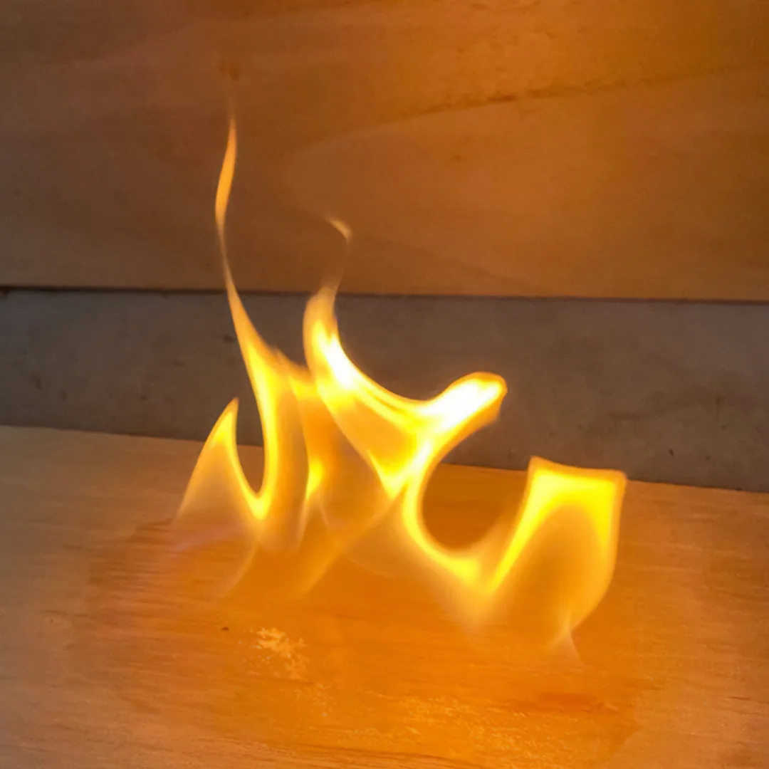 Flames rising from the edge of a paulownia board during a flame-spread test